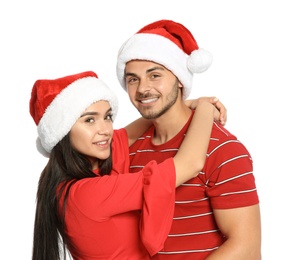 Photo of Young happy couple with Santa hats on white background. Christmas celebration