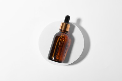 Bottle with cosmetic oil on white background, top view