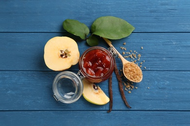 Photo of Delicious quince jam, sugar and fruit on blue wooden table, flat lay