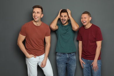 Photo of Group of friends laughing together against gray background