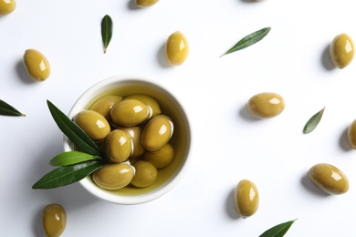 Flat lay composition with fresh olives in oil on white background