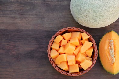 Whole and cut delicious ripe melons on wooden table, flat lay. Space for text