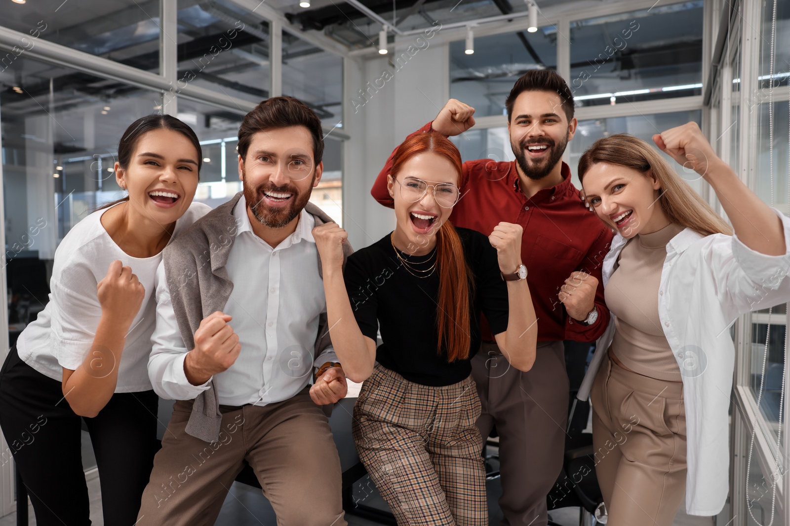 Photo of Team of employees celebrating success in office