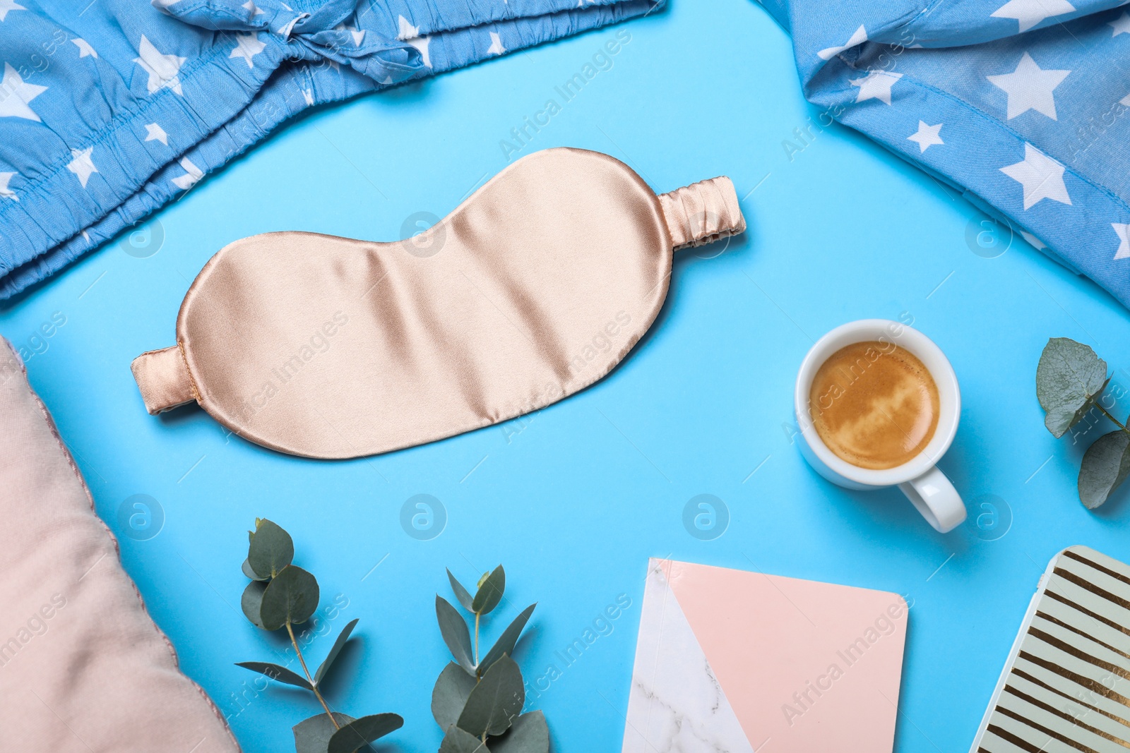 Photo of Flat lay composition with sleeping mask on light blue background. Bedtime accessories