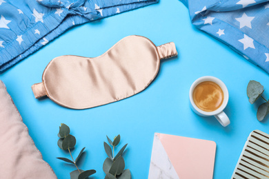 Flat lay composition with sleeping mask on light blue background. Bedtime accessories
