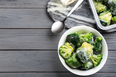 Photo of Flat lay composition with frozen broccoli on light grey wooden table, space for text. Vegetable preservation