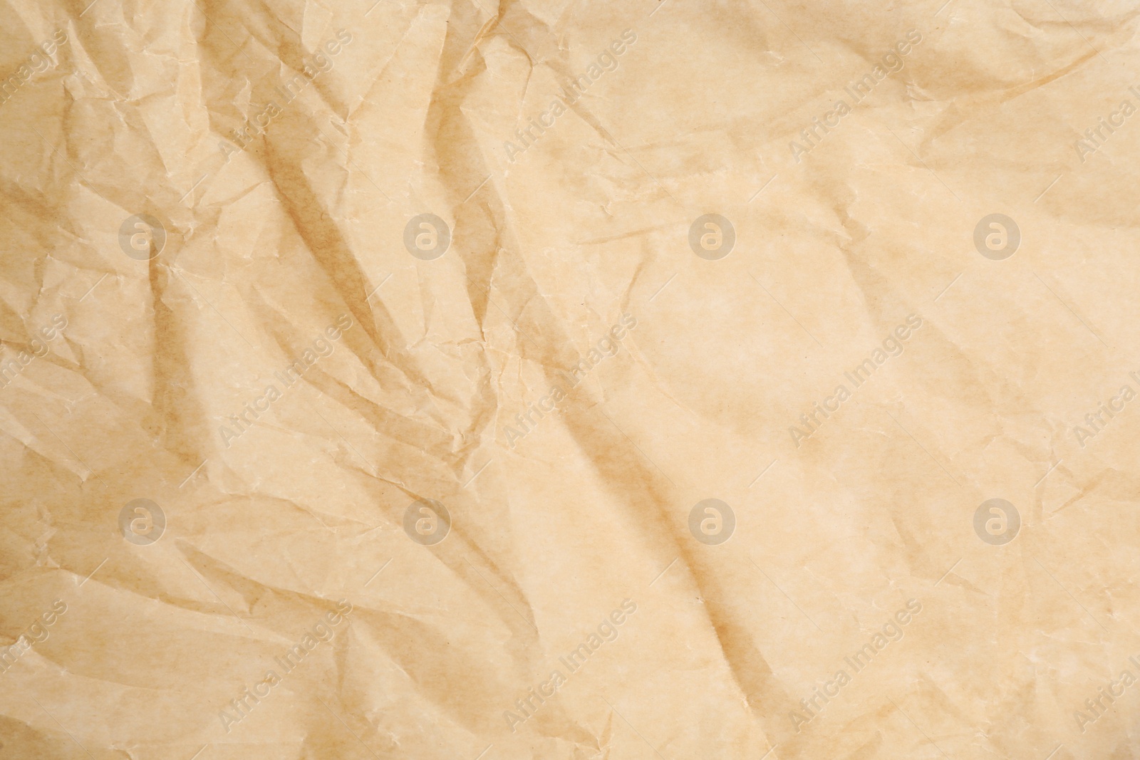 Photo of Texture of crumpled brown baking paper as background, closeup