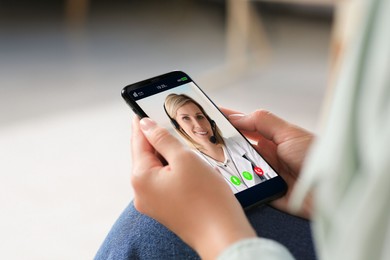 Online medical consultation. Woman having video chat with doctor via smartphone at home, closeup