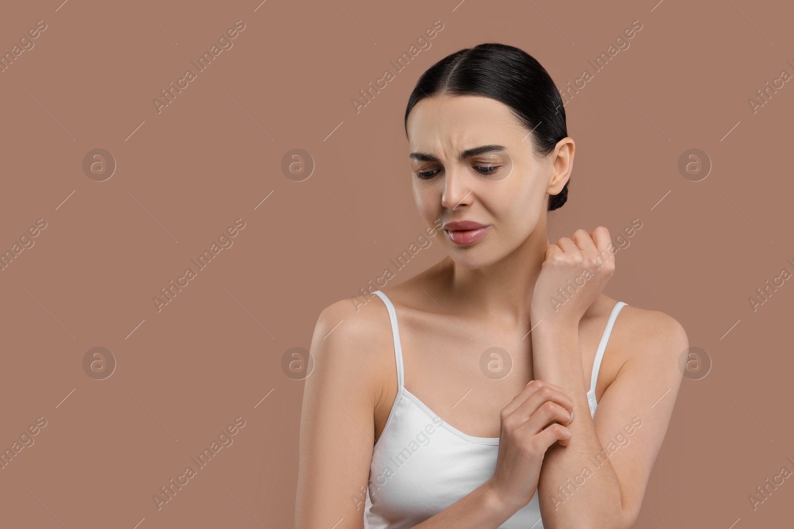 Photo of Woman with dry skin checking her arm on beige background, space for text