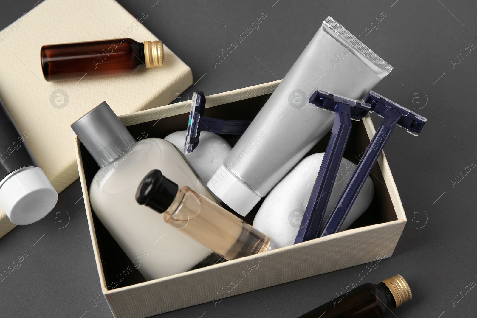 Photo of Different men's shaving accessories and box on dark grey background