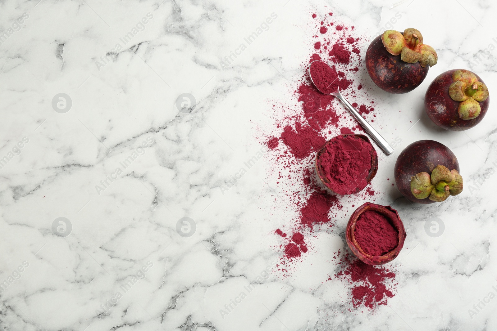 Photo of Purple mangosteen powder and fruits on white marble table, flat lay. Space for text