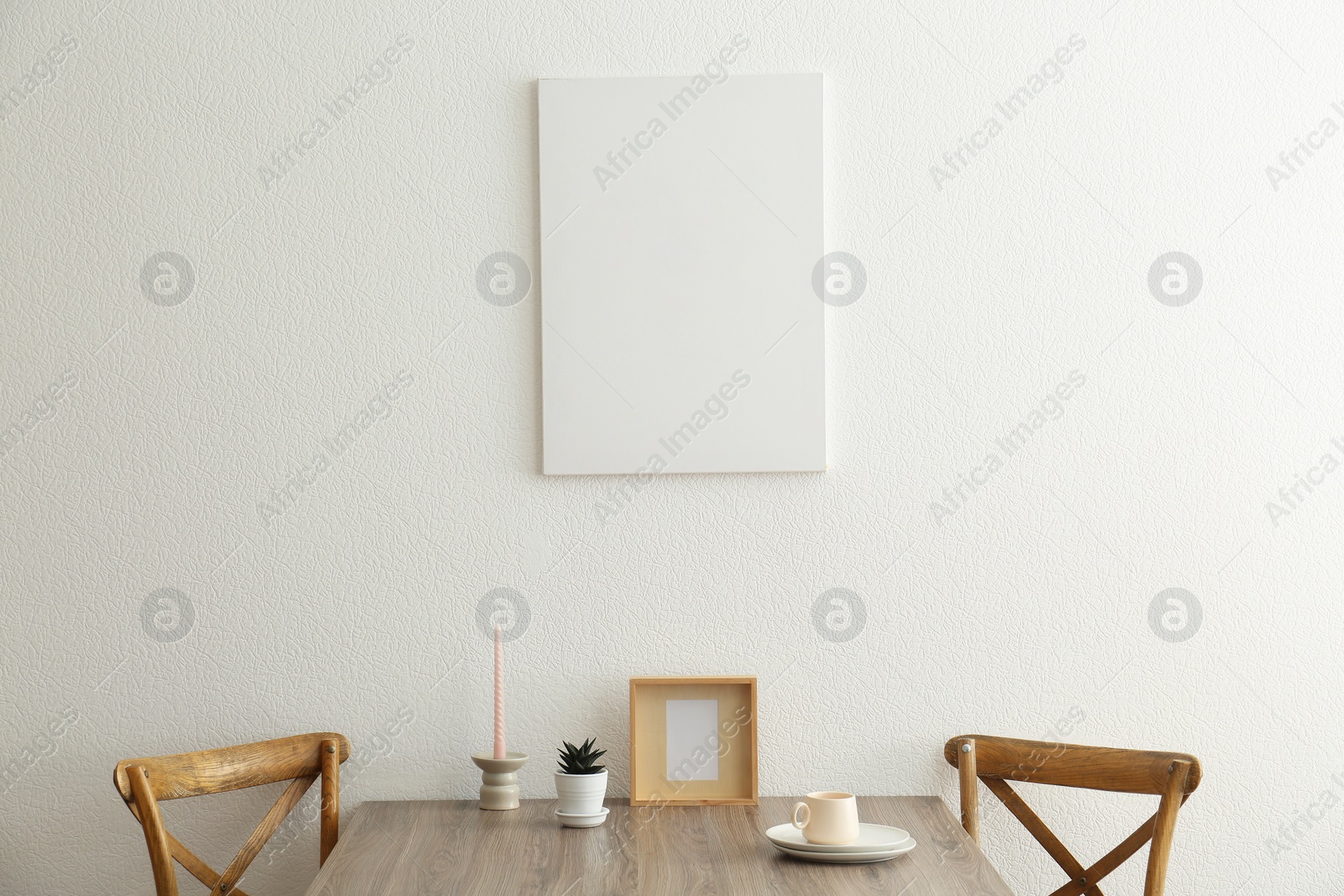 Photo of Room interior with dining table, wooden chairs and poster