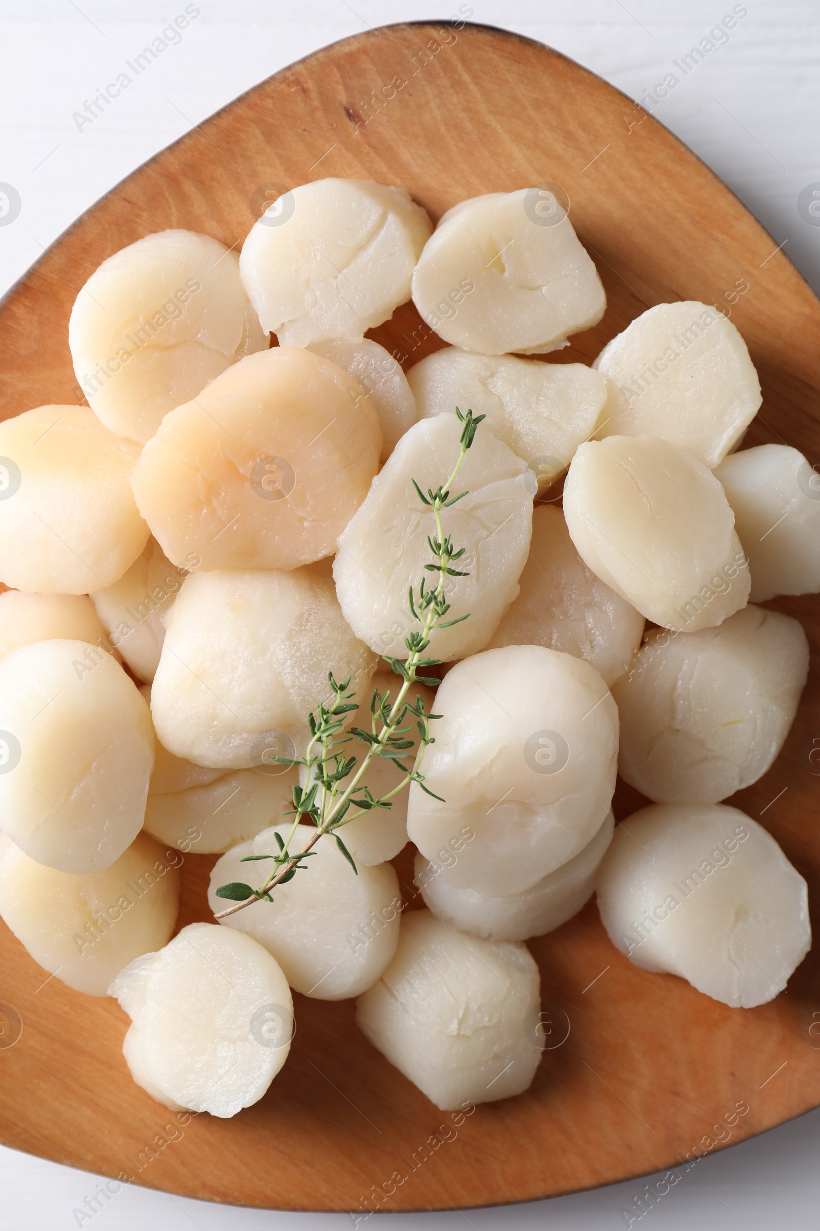 Photo of Fresh raw scallops and thyme on white wooden table, top view