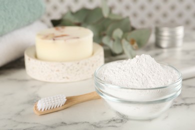 Tooth powder, brush and soap on white marble table, closeup