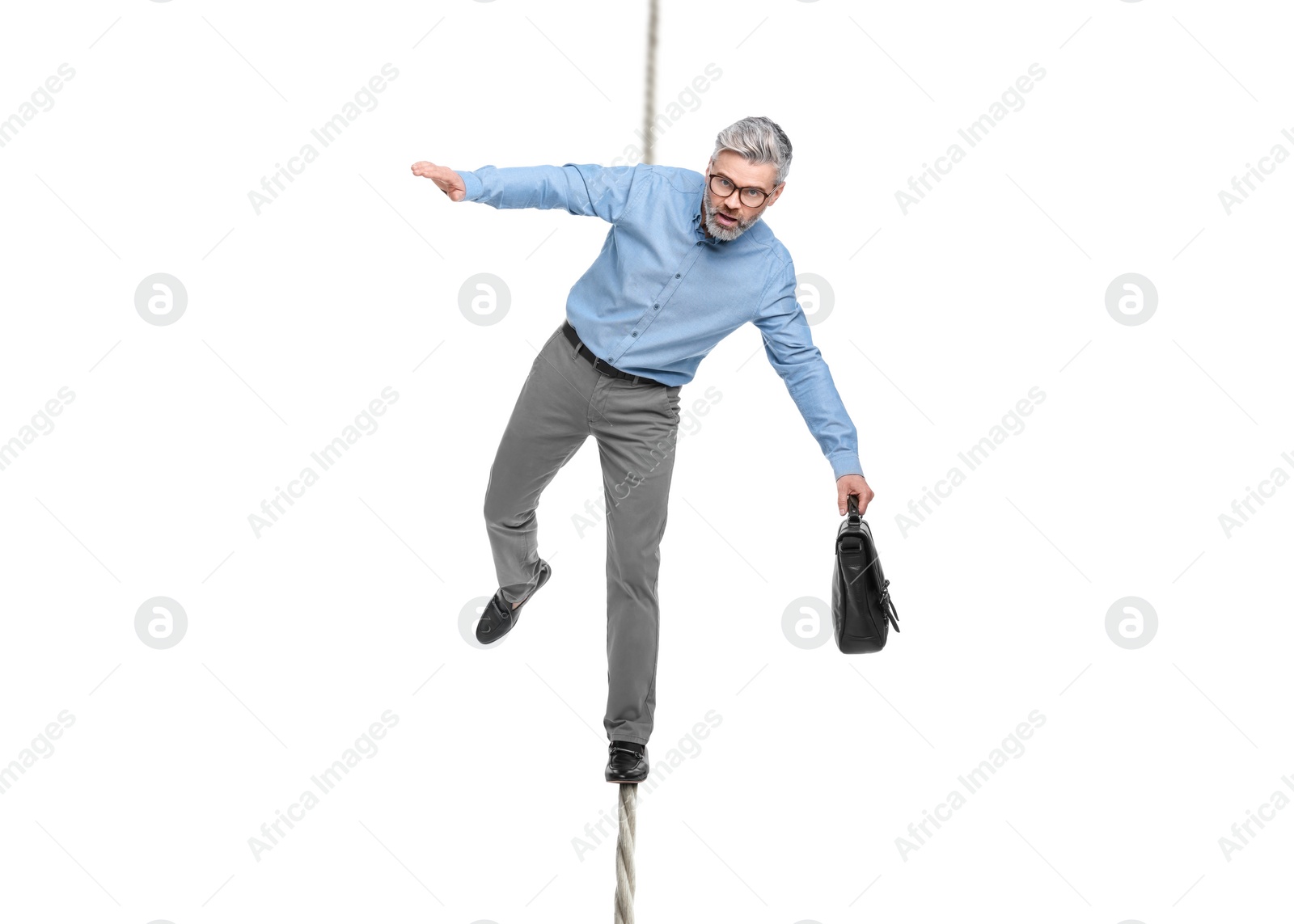 Image of Risks and challenges of owning business. Man with briefcase balancing on rope against white background