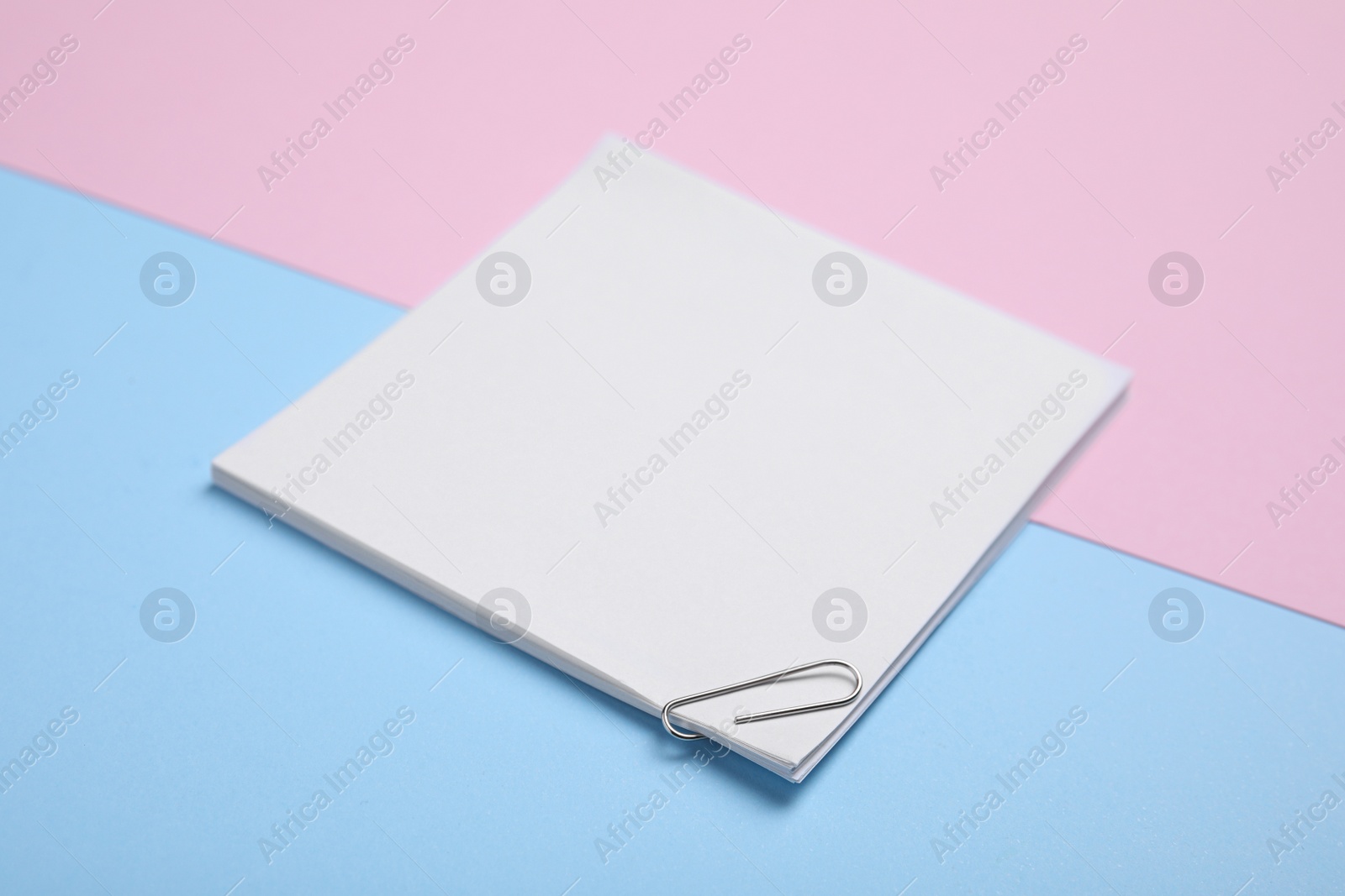 Photo of Sheets of paper with clip on color background