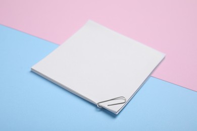 Sheets of paper with clip on color background