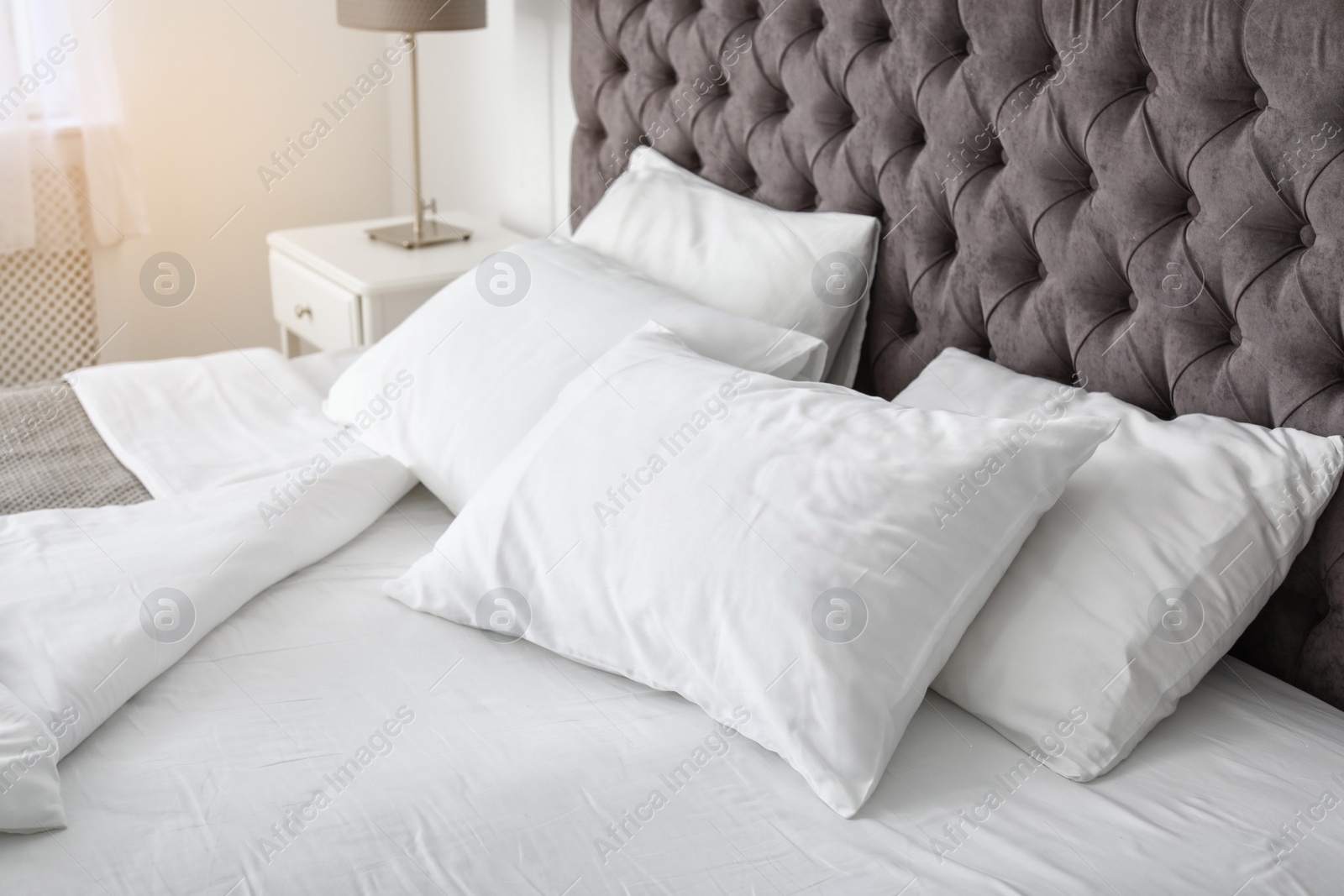 Photo of Soft white pillows on comfortable bed indoors