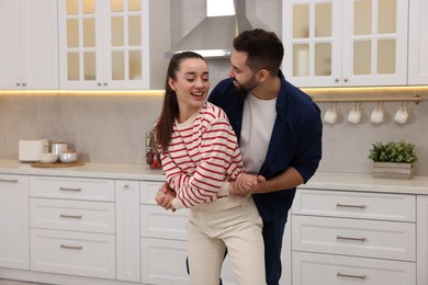 Happy lovely couple dancing together in kitchen