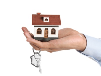 Photo of Real estate agent holding house model and key on white background
