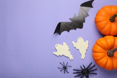 Cardboard bat, pumpkins, felt ghosts and spiders on purple background, flat lay with space for text. Halloween celebration