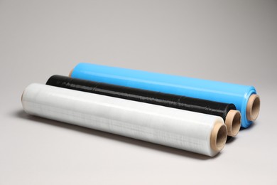 Photo of Rolls of different stretch wrap on light grey background