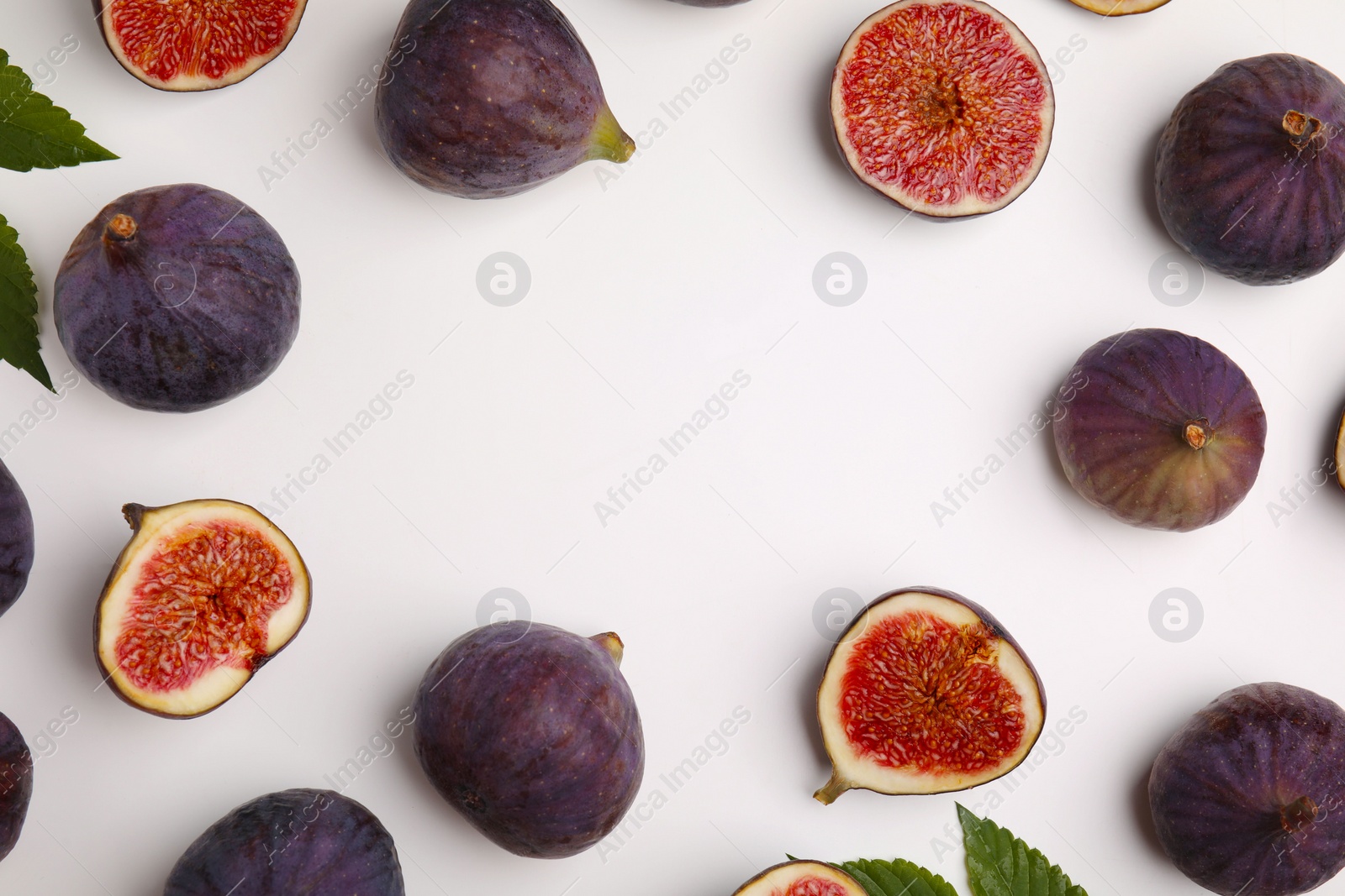 Photo of Frame made with fresh ripe purple figs on white background, top view. Space for text