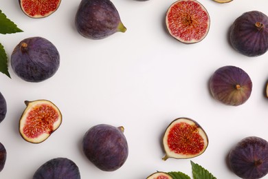 Photo of Frame made with fresh ripe purple figs on white background, top view. Space for text