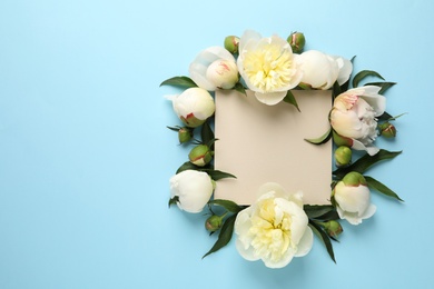 Photo of Fragrant peonies and blank card on color background, flat lay with space for text. Beautiful spring flowers