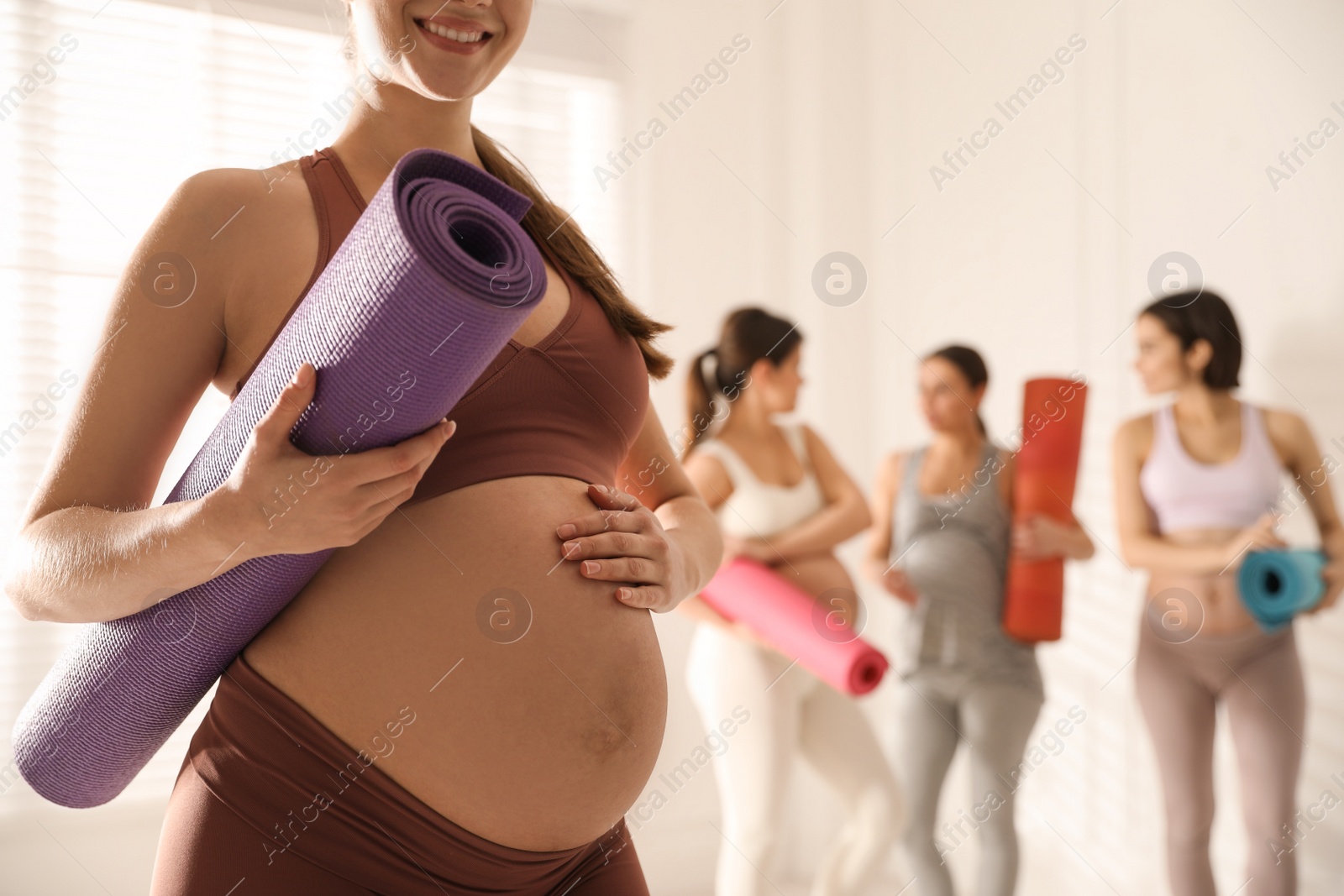 Photo of Group of pregnant women with mats in yoga class, closeup. Space for text