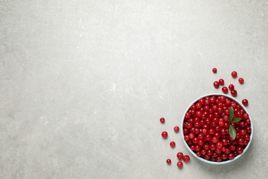 Photo of Tasty ripe cranberries on light grey table, flat lay. Space for text