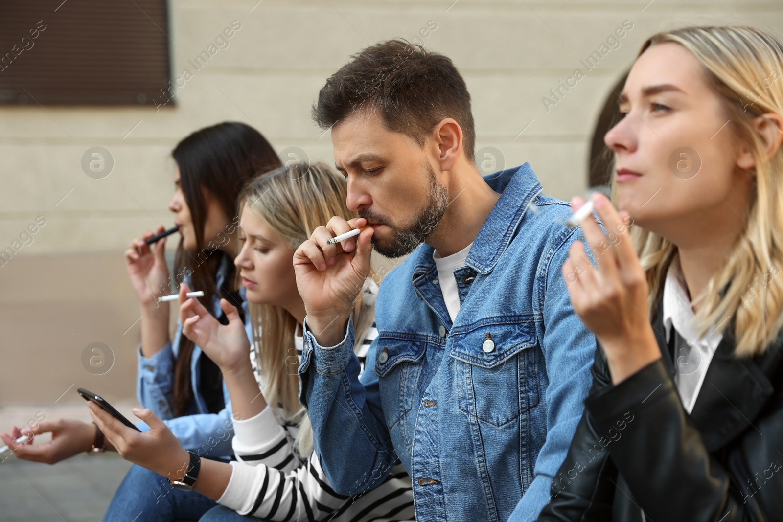 Photo of People smoking cigarettes at public place outdoors