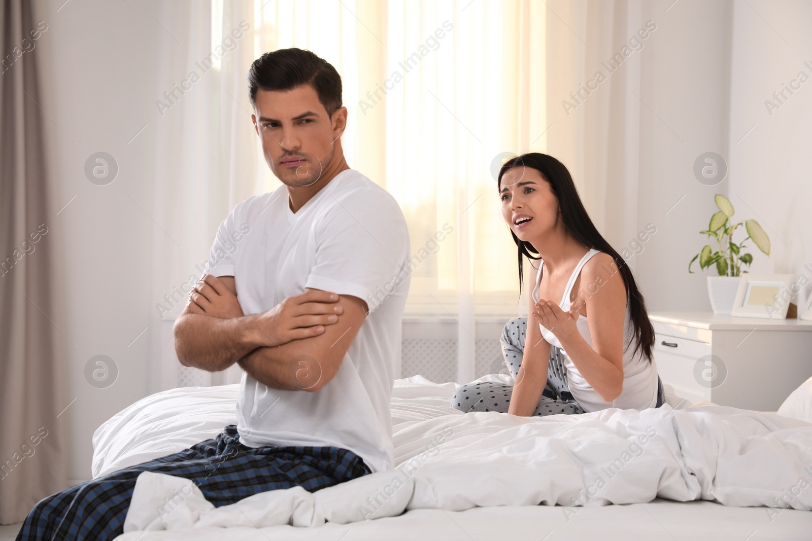 Photo of Couple with relationship problems quarreling in bedroom