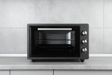 Photo of One electric oven on grey table indoors