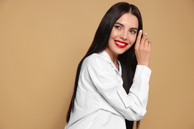 Photo of Portrait of young woman wearing beautiful red lipstick on beige background