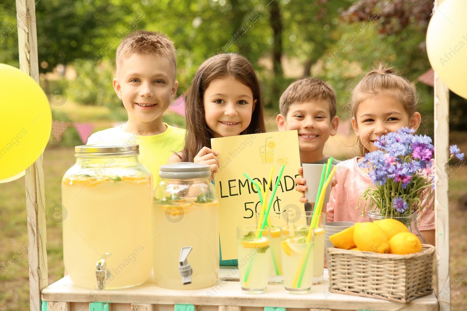 Photo of Little children at lemonade stand in park