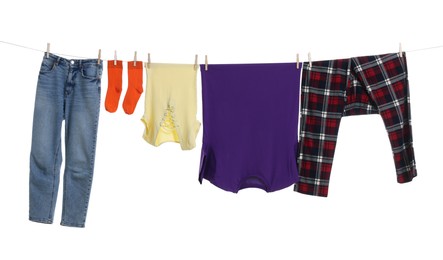 Different clothes drying on laundry line against white background