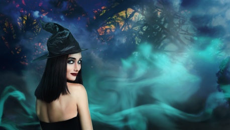 Image of Young girl dressed as witch in misty forest at night. Halloween fantasy