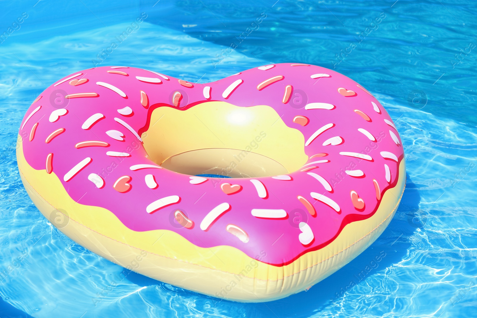 Photo of Heart shaped inflatable heart floating in swimming pool on sunny day