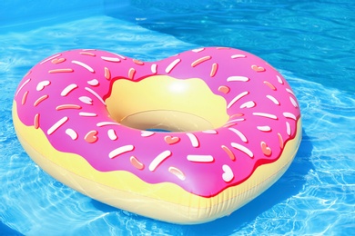 Heart shaped inflatable heart floating in swimming pool on sunny day