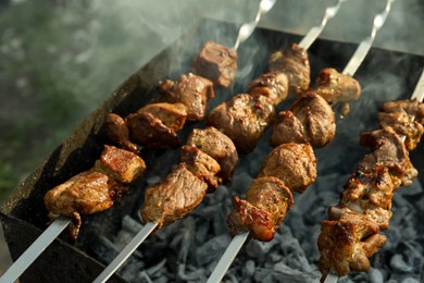 Photo of Cooking delicious meat on brazier outdoors, closeup