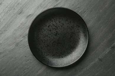 Beautiful ceramic plate on black table, top view