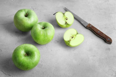 Fresh green apples and knife on table