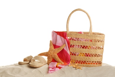 Photo of Stylish bag and different beach accessories on sand against white background