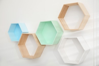 Empty honeycomb shaped shelves on white wall