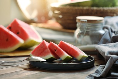 Photo of Sliced fresh juicy watermelon and spoon on wooden table