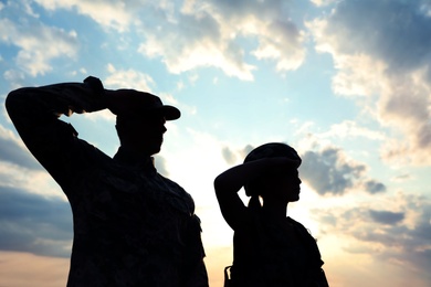 Soldiers in uniform saluting outdoors. Military service