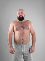 Fat man on grey background. Weight loss