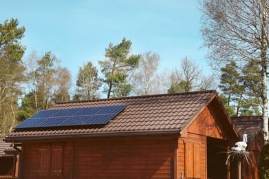 Photo of House with installed solar panels on roof. Alternative energy