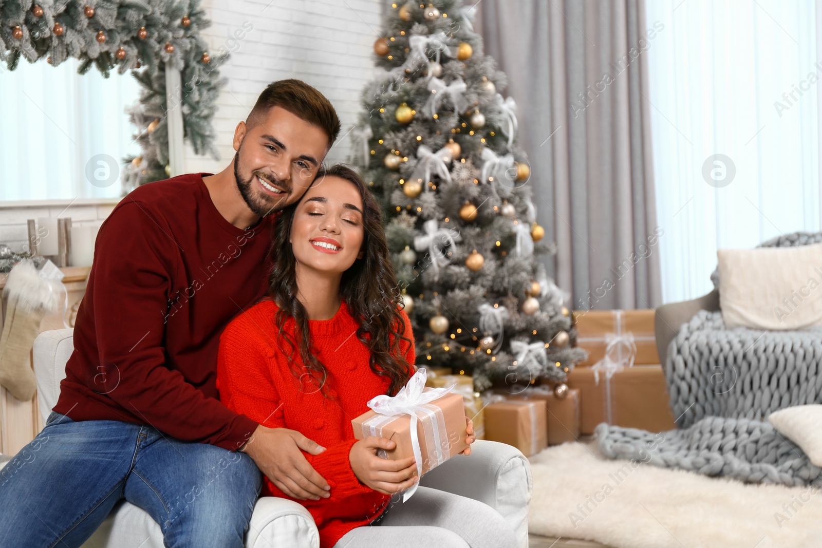 Image of Lovely couple celebrating Christmas together at home